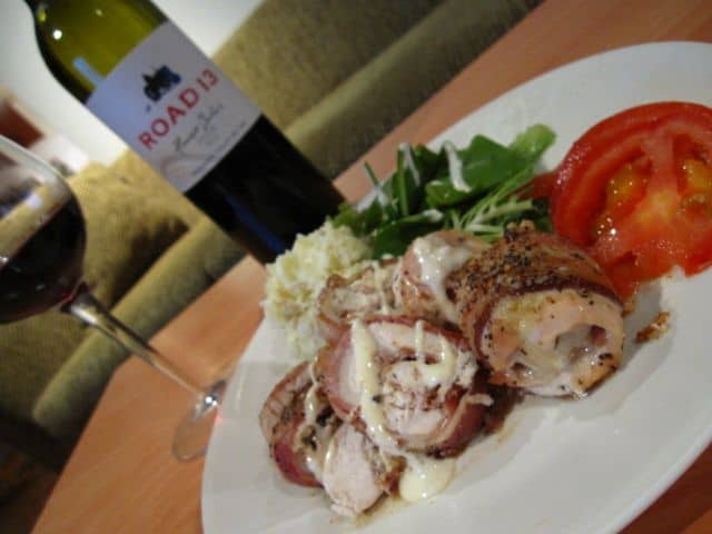 The Finished Chicken Wrapped Bacon On A Plate With Red Wine