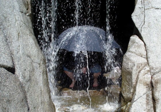 Gina Holding The Unbreakable Umbrella Under A Water Fall