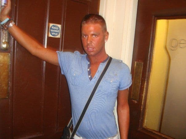 Gay guy with a man purse and fake tan
