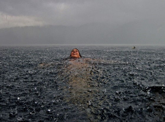 Woman swims in a lake in Chile while it rains