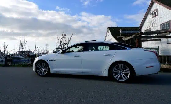 Jaguar XJL next to boats