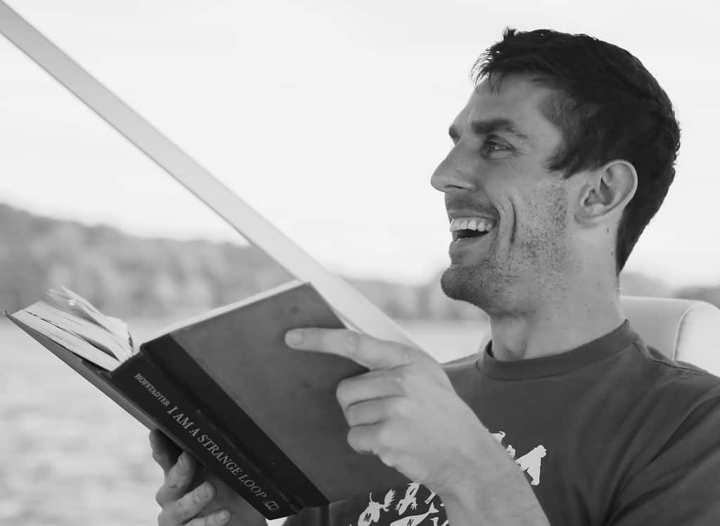 man laughing reading book