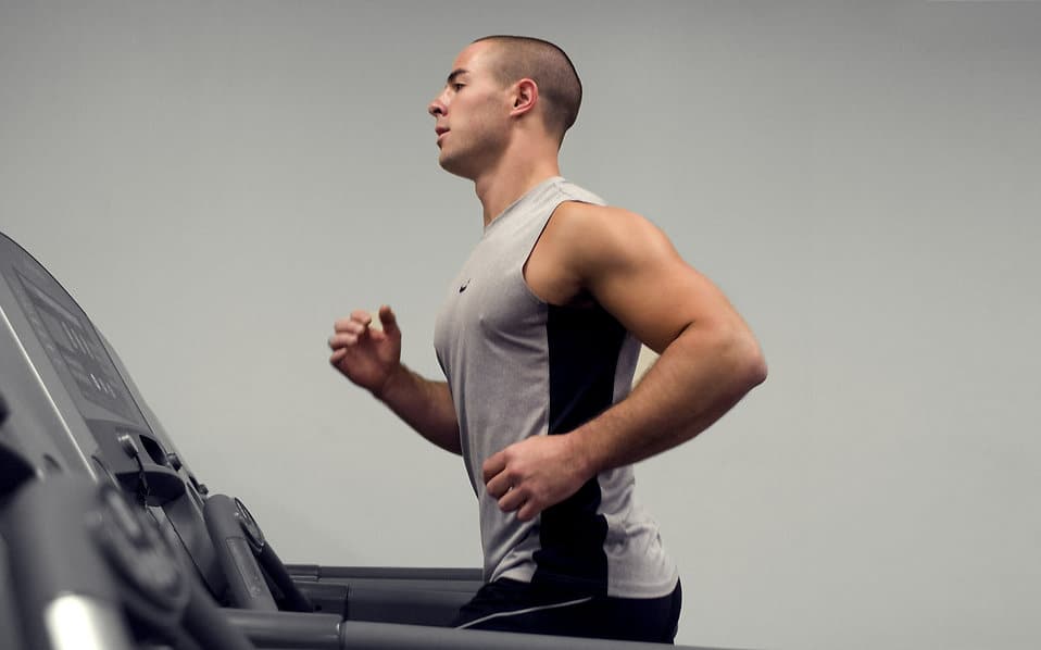 healthy young man running on a treadmill in a gym
