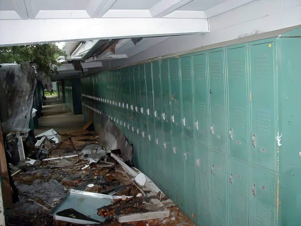 Forgotten Florida - Urbex of Glenridge Middle School 9 Damaged school hallway with toppled lockers and debris, indicating a recent storm or disaster, highlighting the importance of safety precautions in school environments.