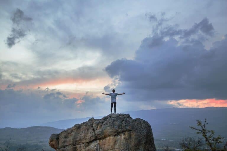 man standing on giant rock