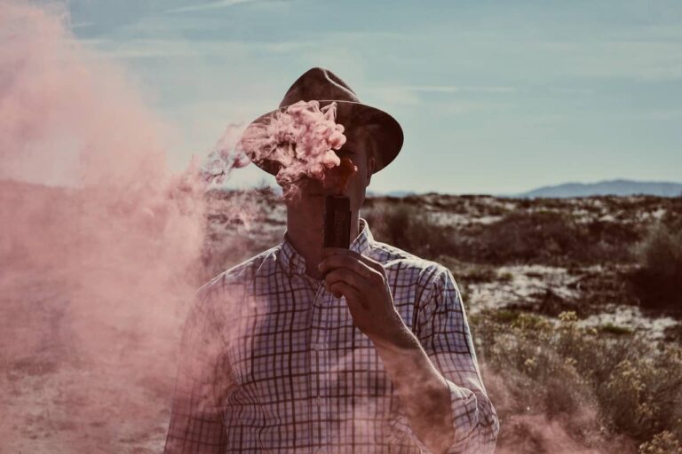 man vaping red smoke