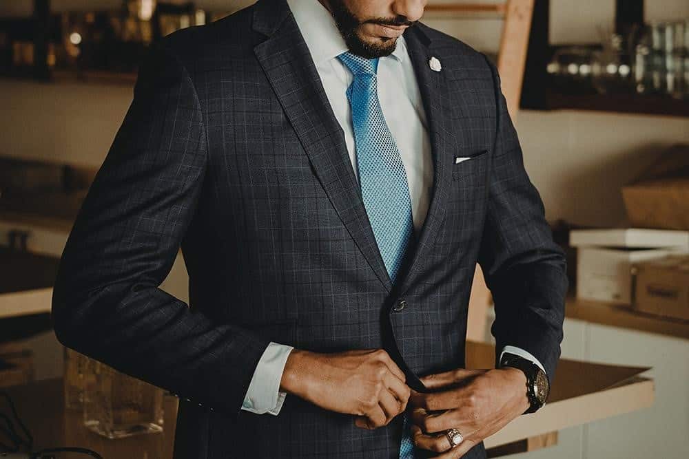 man buttoning suit