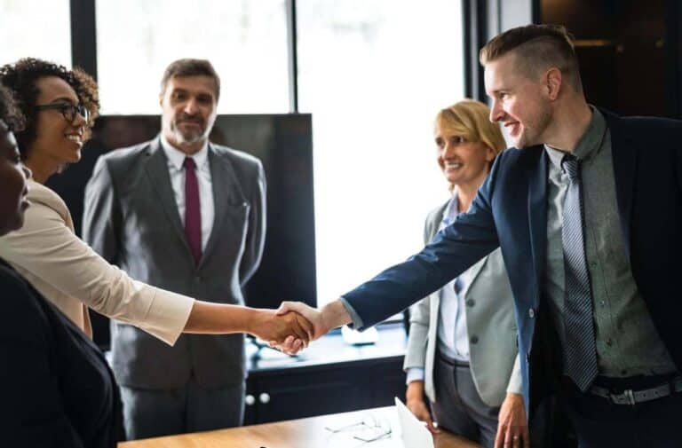 business people shaking across table