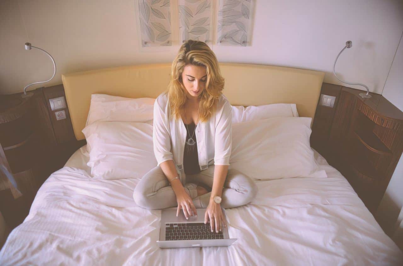 woman using her laptop in bed