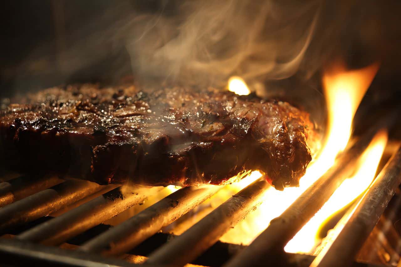 flaming hot steak on a grill