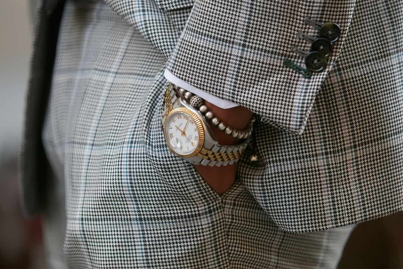 man wearing fancy watch and pearls