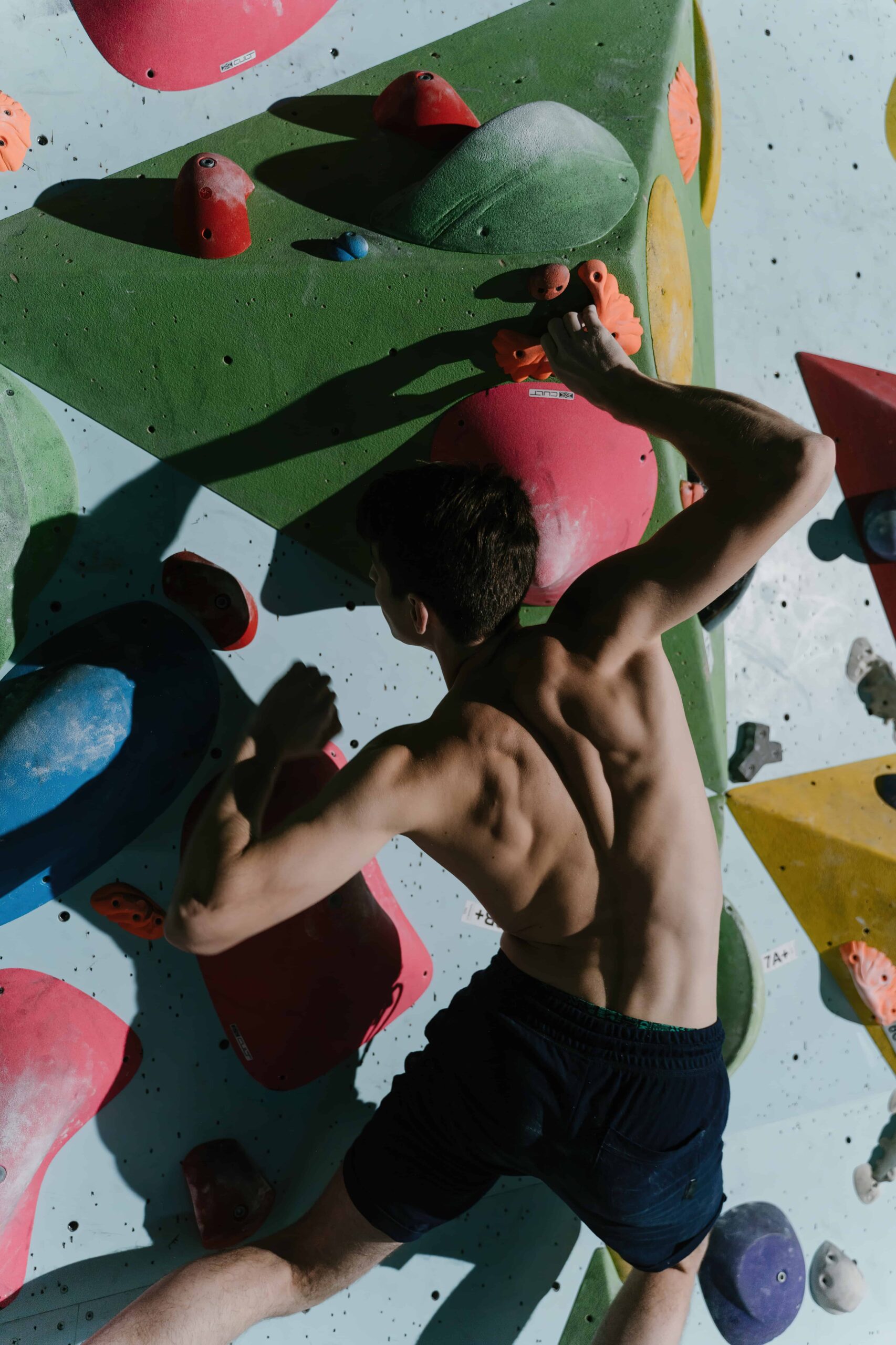 man climbing bouldering gym scaled