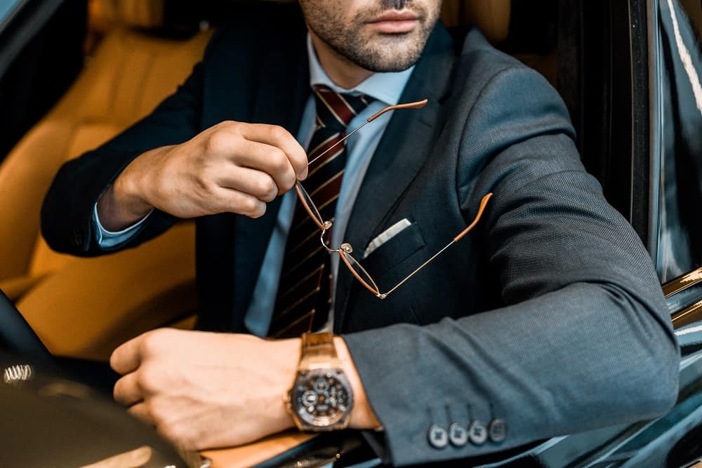 Man in luxury car with Omega watch