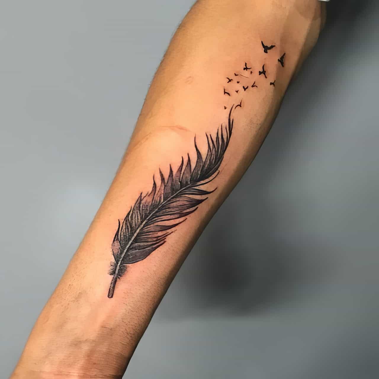 Feather tattoo on the left forearm.
