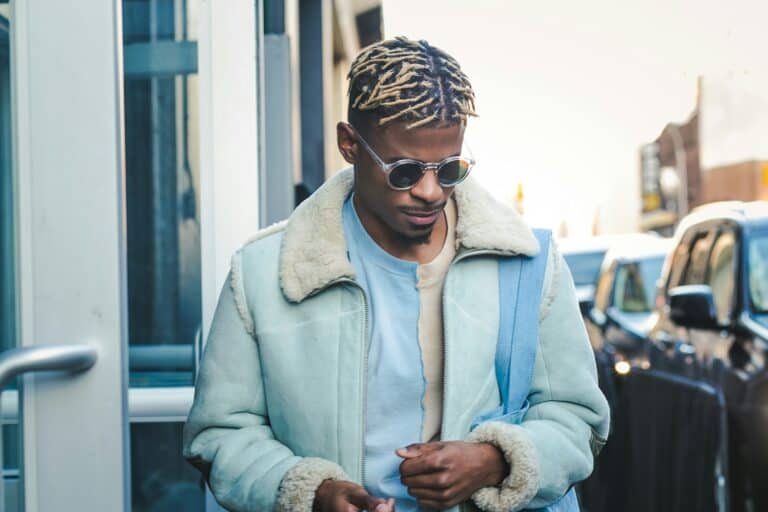 stylish black man wearing sweater and jacket
