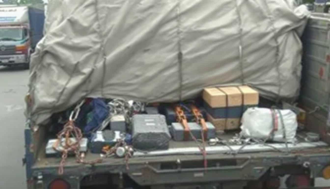 A flatbed truck loaded with secured cargo in an industrial area. A flatbed truck loaded with secured cargo in an industrial area.