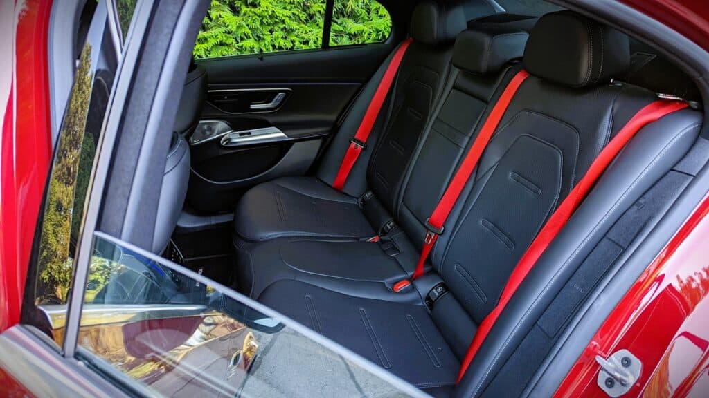 Luxurious car interior with black leather seats and red seatbelt accents, showcasing modern automotive design and comfort features for performance and style.