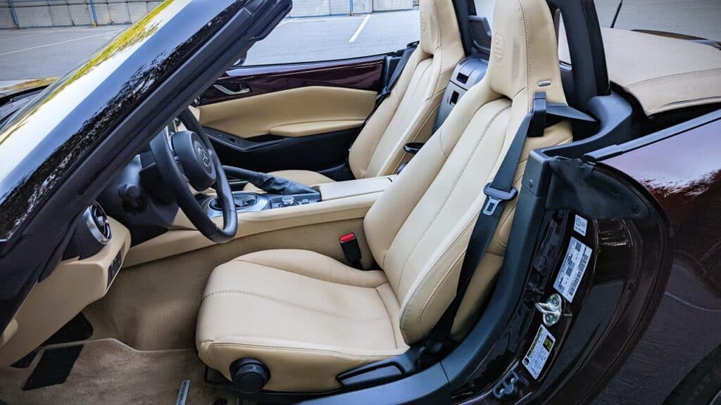 Luxury beige leather car interior focusing on driver and passenger seats with high-end features, perfect for automotive enthusiasts and luxury vehicle reviews.