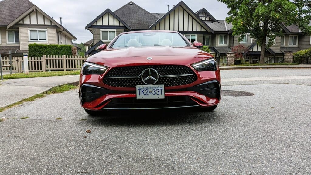 2025 Mercedes-Benz CLE 300 4MATIC Cabriolet Review 2 Luxurious red Mercedes-Benz sports car parked on a residential street with modern homes in the background.