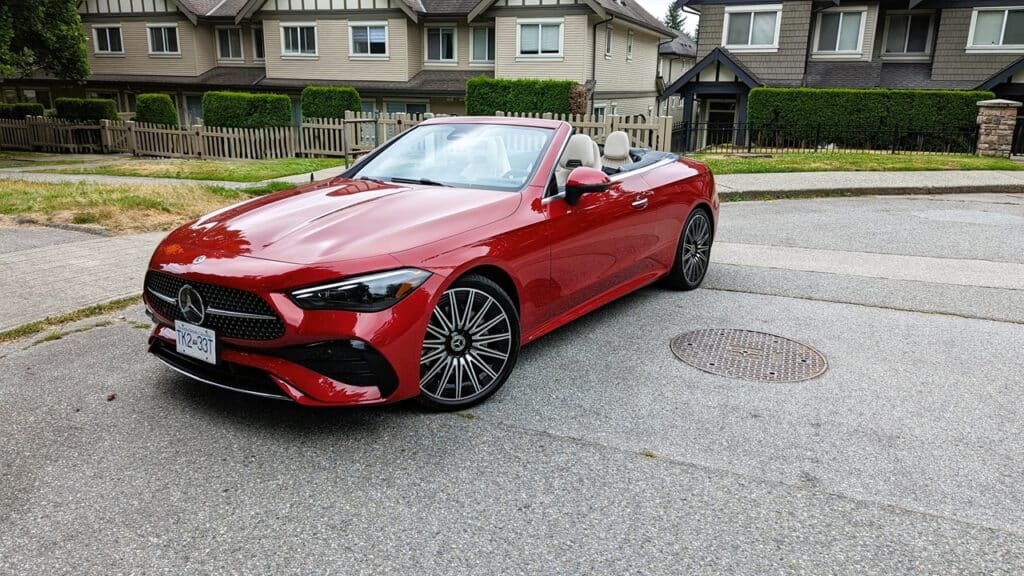 2025 Mercedes-Benz CLE 300 4MATIC Cabriolet Review 5 Sleek red Mercedes-Benz convertible parked on suburban street with modern houses in the background.