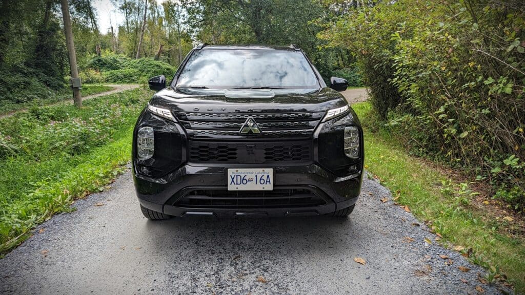 2025 Mitsubishi Outlander PHEV Noir Review 2 Elegant black Mitsubishi Outlander SUV parked on a scenic forest trail in British Columbia, showcasing modern design and rugged outdoor appeal.
