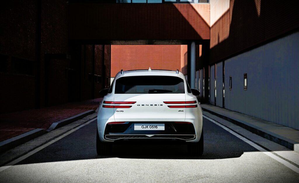 2026 Genesis GV70 Prestige 2.5T AWD Review 2 Genuine electric car parked on urban street with modern architecture, showcasing innovative automotive design and eco-friendly transportation options.