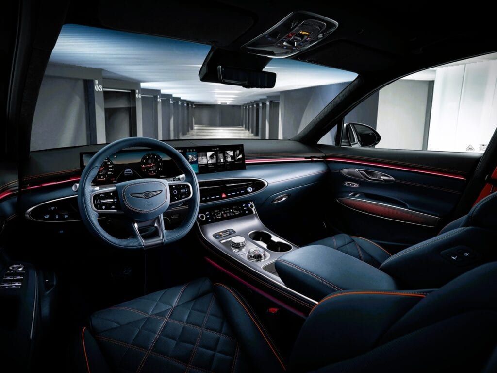 2026 Genesis GV70 Prestige 2.5T AWD Review 4 Luxury car interior, modern dashboard and steering wheel, high-tech infotainment system, black leather seats with red stitching, sleek design, Unfinished Man automotive style, sophisticated vehicle interior, premium automobile features.