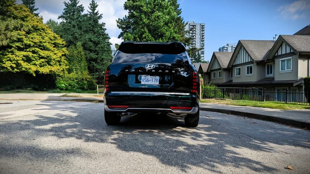 2026 Hyundai Pallisade Ultimate Calligraphy Review 12 Black Hyundai Palisade SUV parked on a residential street with trees and houses in the background.