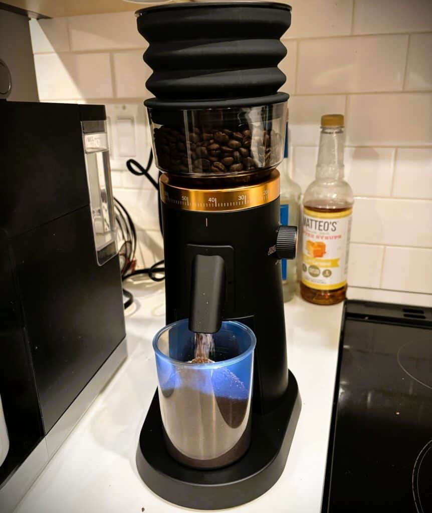 Ground coffee beans being ground for fresh coffee at home, with a sleek coffee grinder on a kitchen countertop. Perfect for coffee lovers and enthusiasts.
