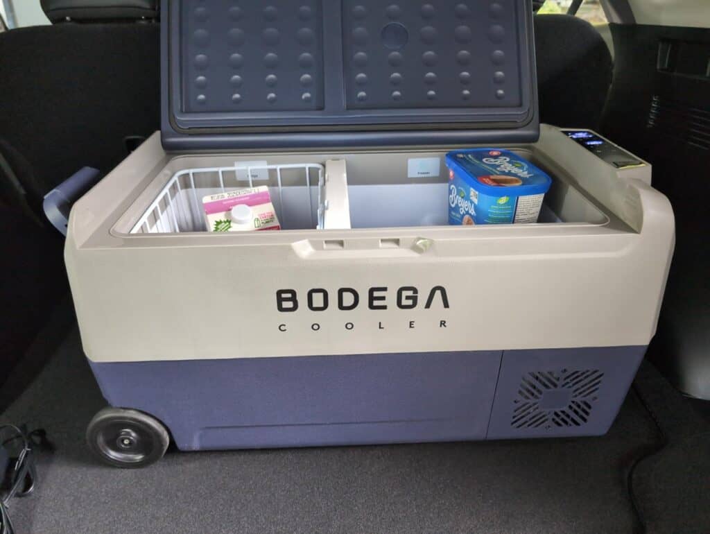 BODEGAcooler 36L Dual Zone 12V Portable Car Fridge Review 6 Cold storage cooler with contents inside, portable beverage cooler for road trips or outdoor activities, featuring Bodega branding and ice retention technology.