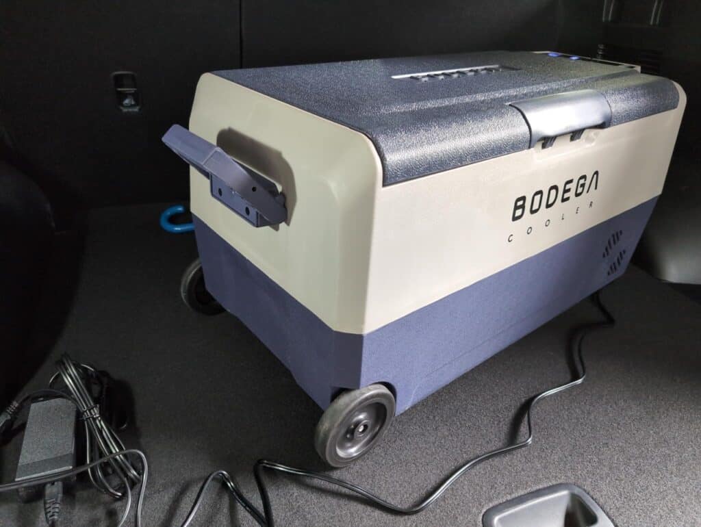 BODEGAcooler 36L Dual Zone 12V Portable Car Fridge Review 4 Portable car fridge cooler on vehicle floor for outdoor travel and camping; compact, energy-efficient, and convenient portable cooling solution.