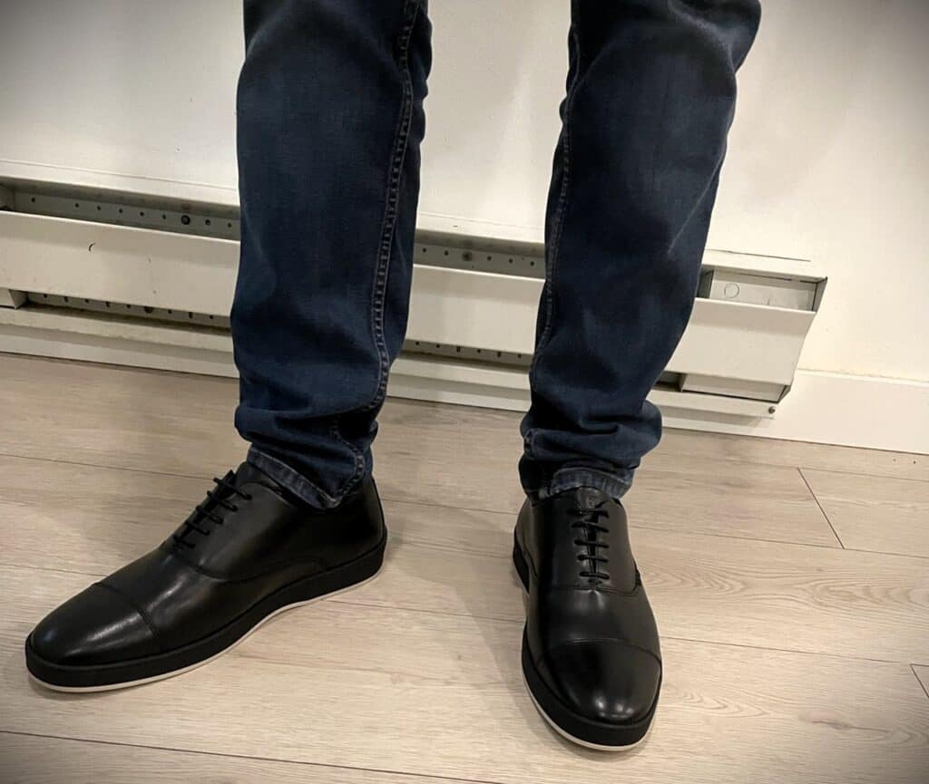 Deming Recovery 'The Westsider' Shoes Review 5 Black men's leather dress shoes with blue jeans, casual style, modern footwear for men, stylish business attire, comfortable and versatile shoes for everyday wear.