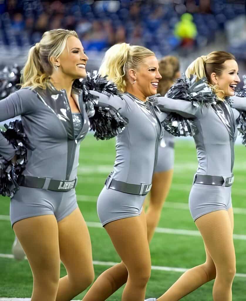 Stunning cheerleaders in coordinated gray uniforms performing during a sports event.
