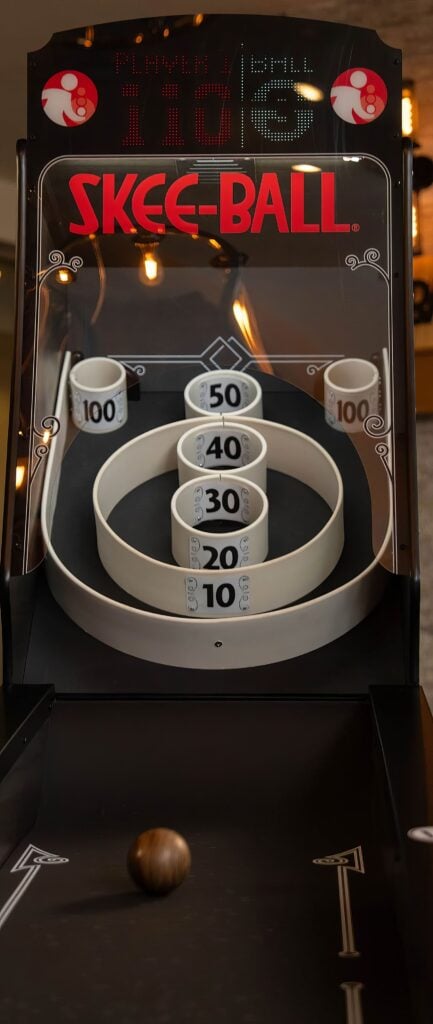 Skee-Ball Premium: 7 Essential Features, Setup & Reviews 2 Skee-ball arcade game with numbered targets and a rolling ball at a fun entertainment venue.