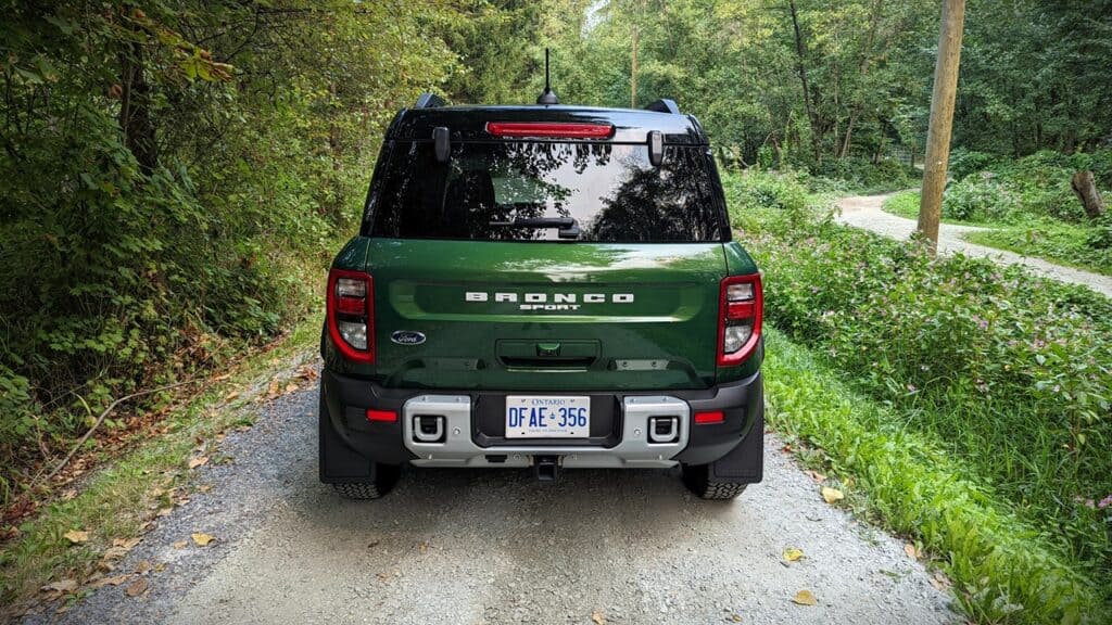 2025 Ford Bronco Sport Outer Banks Review 8 Off-road green and black Ford Bronco Sport SUV on a gravel trail surrounded by lush trees and greenery.