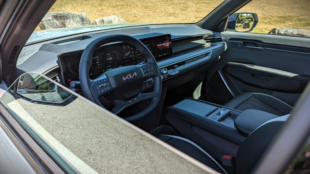 2025 Kia EV9 GT-Line Review 11 Luxury car interior with modern digital dashboard and steering wheel, featuring sleek design and advanced technology for an elevated driving experience. Perfect for car enthusiasts and automotive reviews.