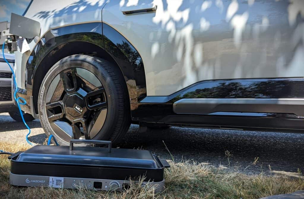 2025 Kia EV9 GT-Line Review 14 Electric vehicle being charged with a portable charging station outdoors, showcasing eco-friendly transportation and modern automotive technology.