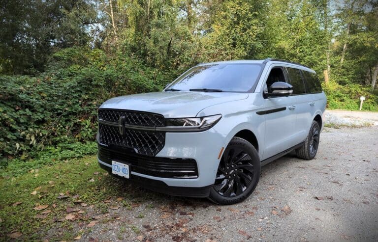 Sleek silver SUV parked outdoors amidst green trees and foliage, showcasing modern design and stylish black accents for an adventurous and sophisticated look.