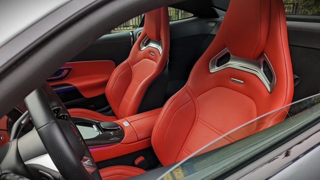 2025 Mercedes-AMG GT 63 4MATIC+ Coupe Review 15 Red luxury car interior with sporty racing seats and carbon fiber accents, showcasing high-end design and craftsmanship in automotive interiors.