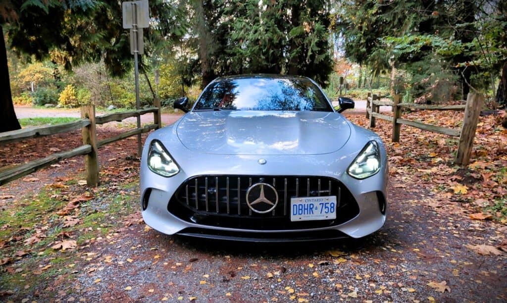 2025 Mercedes-AMG GT 63 4MATIC+ Coupe Review 3 2025 Mercedes-AMG GT 63 sports car parked on a wooded driveway during autumn, showcasing luxury, performance, and stylish design in a scenic outdoor setting.
