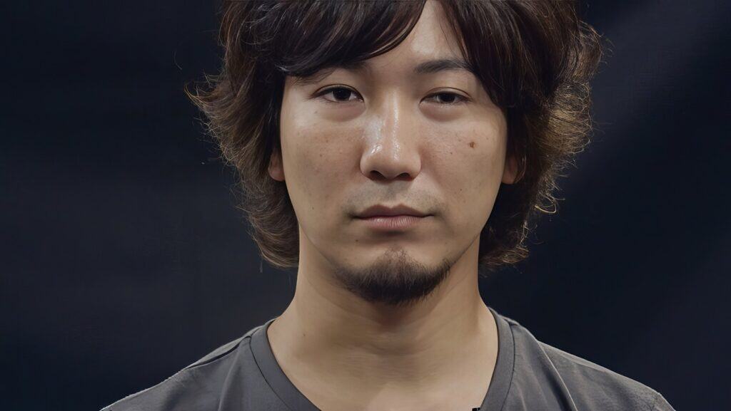 Daigo Umehara: The Legendary Beast's Complete Fighting Game Journey 5 Young Asian man with wavy hair and a subtle beard in a studio setting.