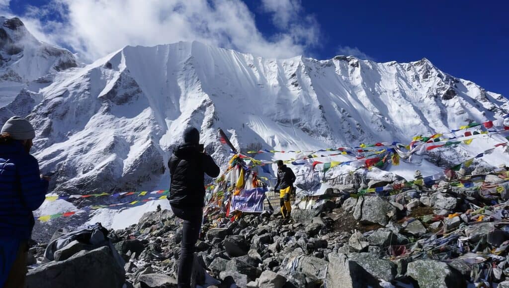 How Difficult Is Manaslu Trek? Challenges & Tips 4 Mount Everest base camp with climbers and prayer flags in the Himalayas snow-covered peaks.