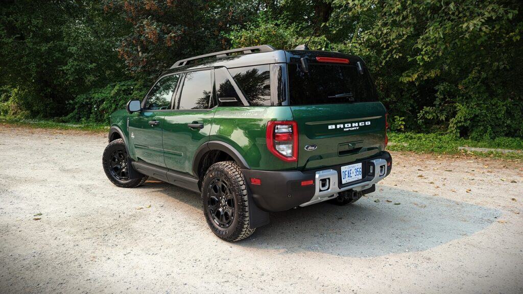 2025 Ford Bronco Sport Outer Banks Review 7 Green Ford Bronco Sport parked on gravel path surrounded by trees.
