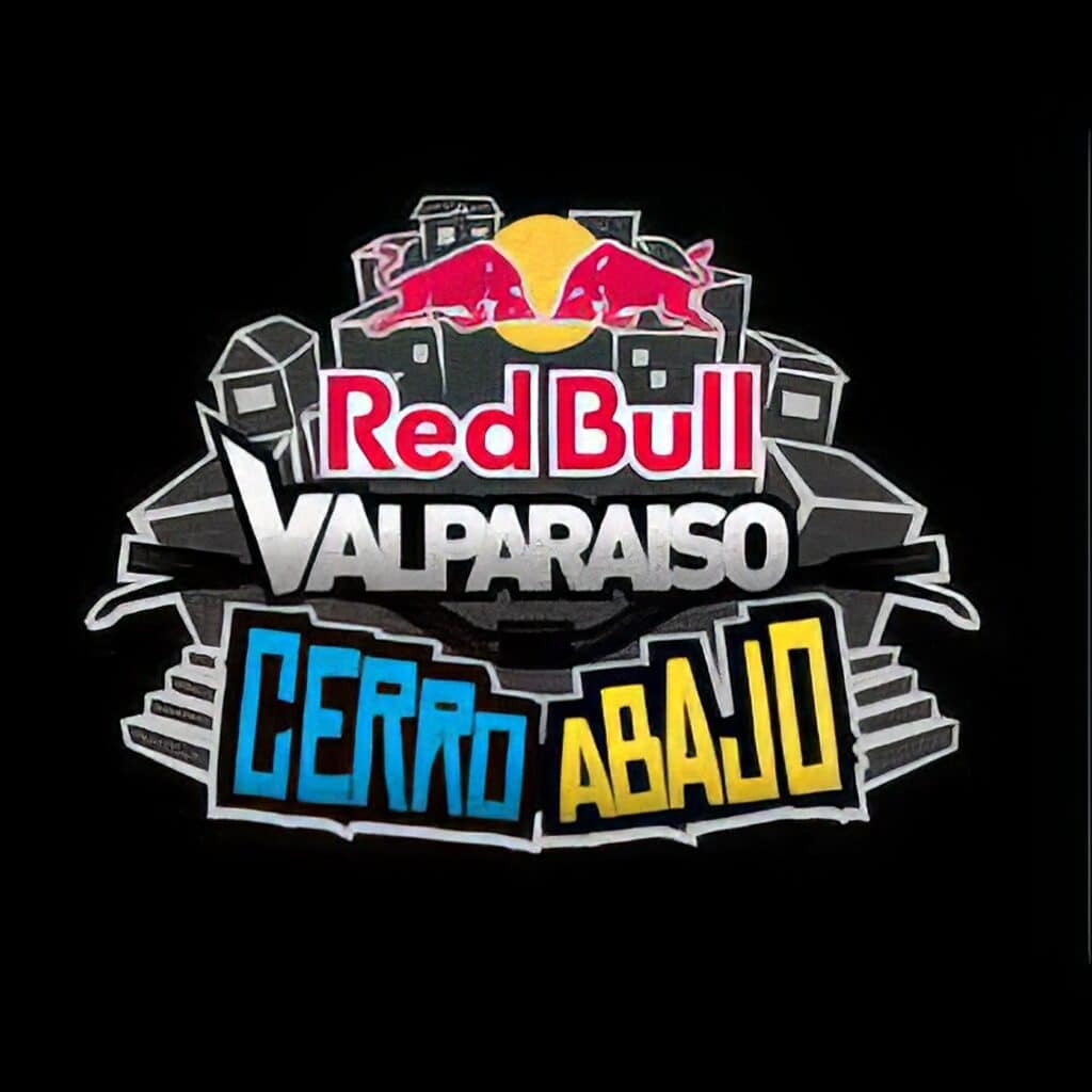 A cyclist navigates a tight urban street while casual onlookers enjoy the lively, everyday atmosphere. Red Bull Valparaiso logo featuring vibrant colors and energetic design, representing the popular motorsport event in Chile, with bold text and dynamic graphics showcasing the event's branding.
