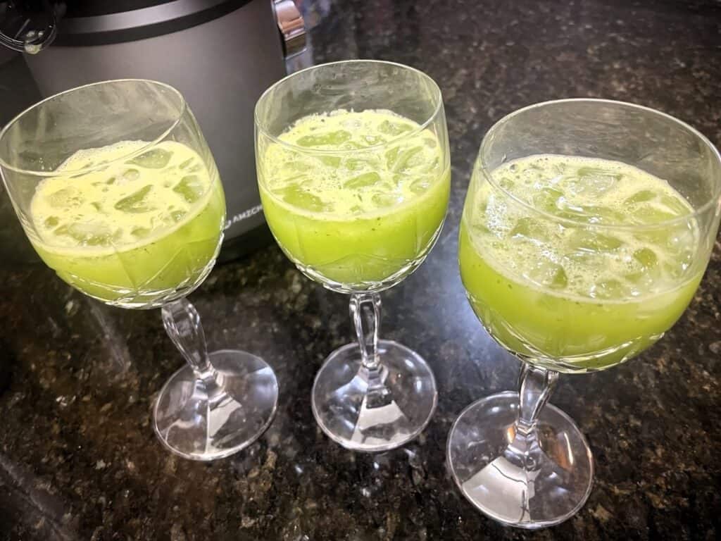 Vibrant green drinks served in stylish wine glasses, perfect for a modern gathering or celebration, showcasing colorful beverage presentation.
