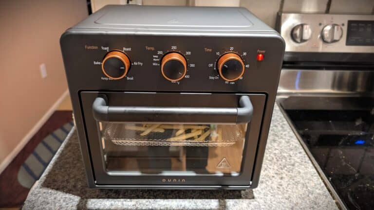 Toaster oven on kitchen countertop with adjustable temperature, timer, and baking functions, perfect for quick meal prep. The oven has a glass door, allowing you to monitor your food, and is suitable for baking, toasting, broiling, and reheating.