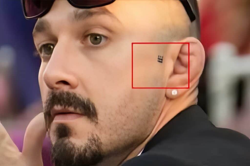 Close-up of man with ear tattoo and well-groomed beard, emphasizing men's grooming, tattoos, and personal style.