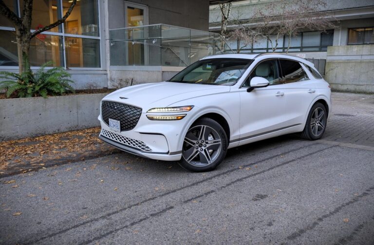Electrified Genesis GV70 Prestige SUV parked outdoors in an urban setting.