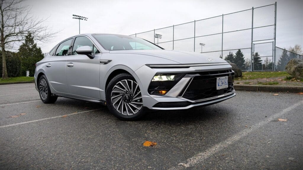 Modern Hyundai Sonata Hybrid parked on a wet outdoor court.