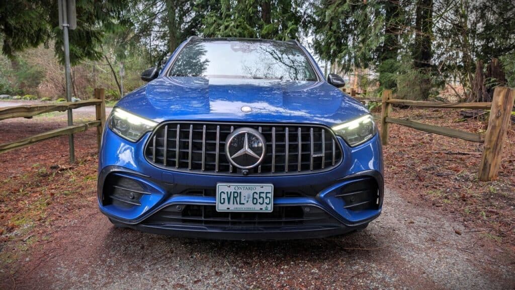 2026 Mercedes-AMG GLC 63 S E Performance Review 2 Blue 2026 Mercedes-AMG GLC 63 S E Performance SUV front view in a wooded area.